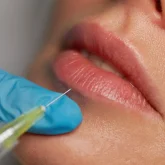 closeup-syringe-with-needle-over-female-lips-2024-12-05-18-05-15-utc closeup-syringe-with-needle-over-female-lips-2024-12-05-18-05-15-utc